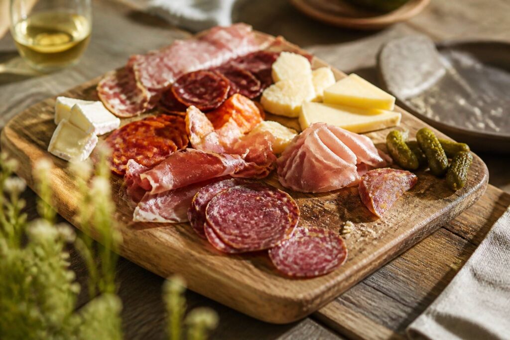 Planche en bois garnie de charcuterie et de fromage pour un apéritif