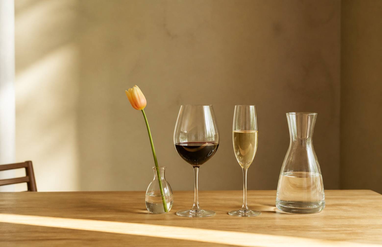 Tulipe universelle, grand verre à rouge et flûte alignés sur une table